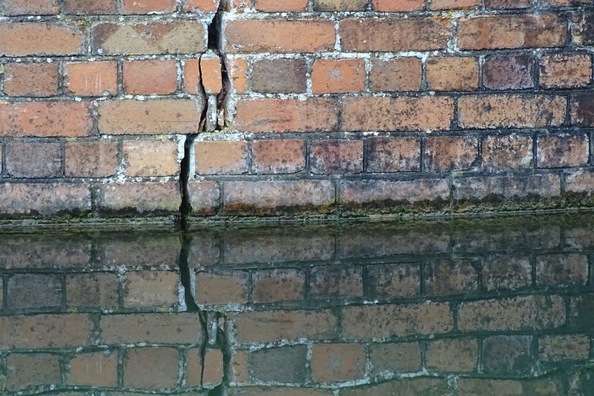 eine Backsteinmauer neben einem Gewässer